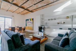 una sala de estar con sofás azules y una mesa. en Decô Apartments Barcelona-Diagonal, en Barcelona