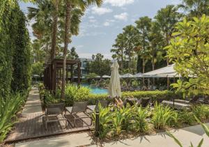 a pool at a resort with chairs and a umbrella at Stay Wellbeing & Lifestyle Resort in Rawai Beach +37 photos
