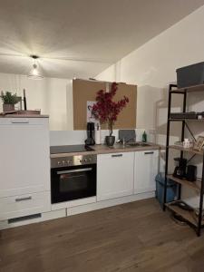 a kitchen with white cabinets and a black oven at Emsquartier Apartment No 2 in Emsdetten