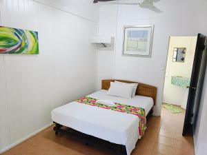 阿皮亚Olivias Accommodation的卧室里有一张床，墙上挂着一幅画