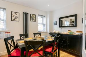 ein Esszimmer mit Tisch und Stühlen und einem Spiegel in der Unterkunft Cosy 3 Bedroom Home Next to Bicester Village! in Bicester