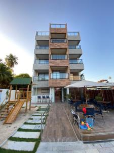 a tall building with chairs and tables in front of it at Flat na beira-mar de Tamandaré in Tamandaré +45 photos