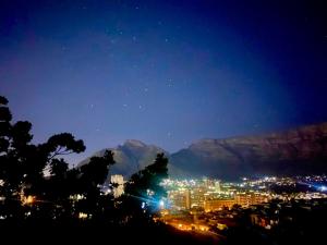 a view of a city at night with a mountain at Casa Finchette rooftop apartment with panoramic views of Table Mountain in Cape Town