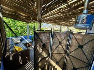 a screened in porch with a couch and a bird cage at Casa Finchette rooftop apartment with panoramic views of Table Mountain in Cape Town