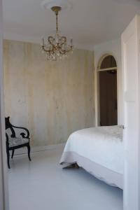 a bedroom with a bed and a chandelier at Kaunis asunto Pyynikillä in Tampere
