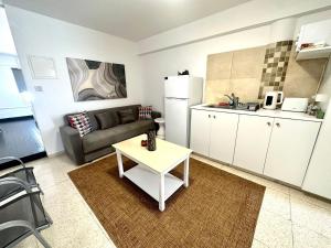 a living room with a couch and a table in a kitchen at Harbour Seaside Escape in Ayia Napa +9 photos