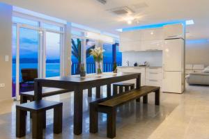 eine Küche mit einem Tisch und Bänken in einem Zimmer in der Unterkunft Luxury at Villa Cama - Your dream vacation Rental in Posedarje