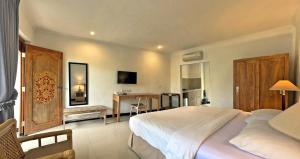 a bedroom with a large white bed and a desk at Sanur Lodge in Sanur