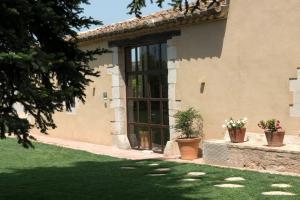 a building with a large window and potted plants at Mas Pla in Riudellots de la Selva
