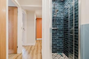 a bathroom with a shower with blue tiles on the wall at Country Cottage in the Heart of the Cotswolds! in Farmington +57 photos