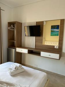 1 dormitorio con TV y 1 cama con toallas en Villa Juli Ksamil, en Ksamil