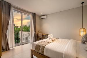 スミニャックにあるVilla Umabell Villa Seminyakのベッドと大きな窓のある寝室