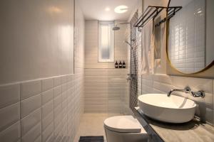 スミニャックにあるVilla Umabell Villa Seminyakの洗面台とトイレを備えた白いバスルーム