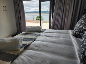a bed in a room with a large window at BondMakers Blue Canoe in Hartbeespoort +18 photos