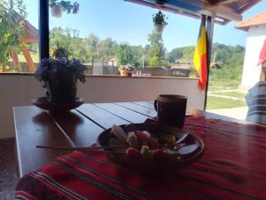 a table with a bowl of fruit on a table at PRIDVOR de STOENESTI in Bîrlogu