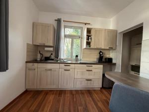 a kitchen with white cabinets and a sink and a window at Ferienapartment Weimar Altstadt 1 in Weimar +7 photos