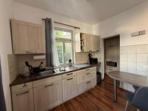 ワイマールにあるFerienapartment Weimar Altstadt 1のキッチン(木製キャビネット、シンク、テーブル付)