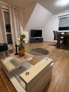 a living room with a table and a television at Apartment Tilda Steinbeck in Recke