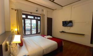 una camera con letto e TV a parete di Hotel Juju a Pokhara