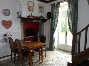 una sala da pranzo con tavolo e camino di Chez Beaumont - Gite a Saint-Sébastien