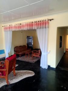 a living room with white curtains and a couch at Camelliya Guest House in Kandapola