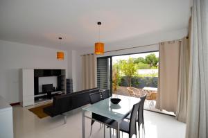 a dining room and living room with a table and chairs at Vilas Espírito Santo in Porto Santo