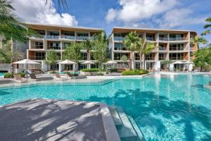 a swimming pool in front of a hotel at Wyndham Grand Nai Harn Beach Phuket in Nai Harn Beach
