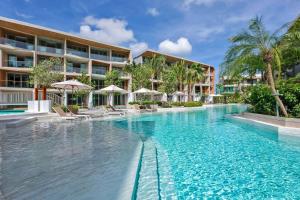 a swimming pool in front of a hotel at Wyndham Grand Nai Harn Beach Phuket in Nai Harn Beach