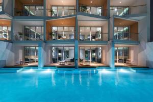 a building with a swimming pool in front of it at Wyndham Grand Nai Harn Beach Phuket in Nai Harn Beach