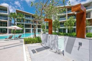 an image of a building with a swimming pool at Wyndham Grand Nai Harn Beach Phuket in Nai Harn Beach