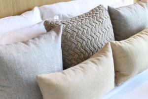 a pile of pillows sitting on top of a bed at Wyndham Grand Nai Harn Beach Phuket in Nai Harn Beach