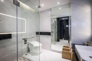 a bathroom with a shower and a toilet and a sink at Wyndham Grand Nai Harn Beach Phuket in Nai Harn Beach