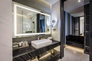 a bathroom with a sink and a mirror at Wyndham Grand Nai Harn Beach Phuket in Nai Harn Beach
