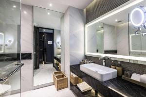 a bathroom with a sink and a mirror at Wyndham Grand Nai Harn Beach Phuket in Nai Harn Beach