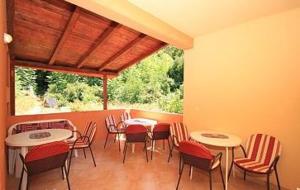 a patio with tables and chairs and a window at Villa Elvira in Gradac