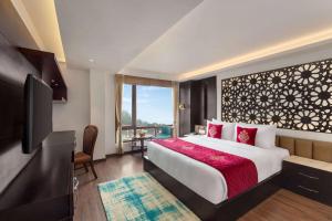 ガントクにあるRamada by Wyndham Gangtok Hotel & Casino Goldenのベッドとテレビがあるホテルの部屋