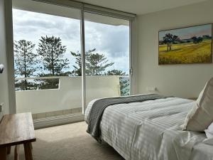 a bedroom with a bed and a large window at Best Beachfront Location In Manly w Stunning Views in Sydney