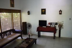 a living room with a couch and a desk with a computer at Sanuk bungalows in Rawai Beach