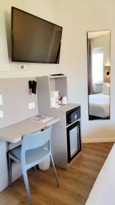 a room with a desk with a television and a bed at Hotel Aurora Duino in Duino