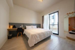 una camera da letto con un letto, una scrivania e una finestra di Chunzi Apartment B&B a Magong
