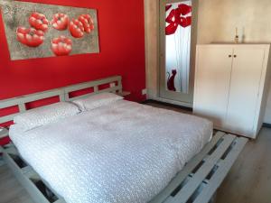a bedroom with a white bed and a red wall at La Cà ët Mec in Robilante