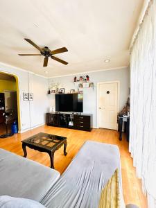 a living room with a couch and a table at Feel at Home Polomolok WiFi 300mbps Netflix 75in TV in Polomolok