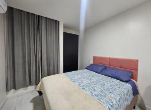 a bedroom with a bed and a large window at Flat alto padrão Intermares in Cabedelo