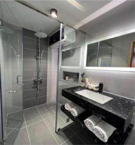 a bathroom with a shower and a sink and a mirror at In The Pines Homestay & Coffee in Da Thanh
