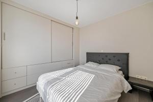 ein Schlafzimmer mit einem großen Bett mit weißen Schränken in der Unterkunft Modern Penthouse with Unique Terraces! in Ostende
