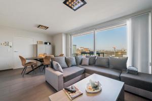 ein Wohnzimmer mit Sofa und Tisch in der Unterkunft Modern Penthouse with Unique Terraces! in Ostende