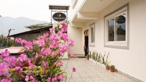 un edificio con fiori rosa di fronte di Sherabling a Gangtok