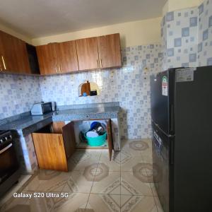 a kitchen with a sink and a refrigerator at Wema centre apartment in Gatunga
