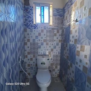 a bathroom with a toilet and a window at Wema centre apartment in Gatunga
