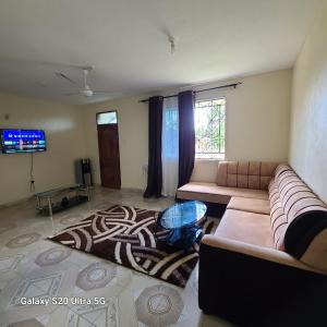 a living room with a couch and a tv at Wema centre apartment in Gatunga